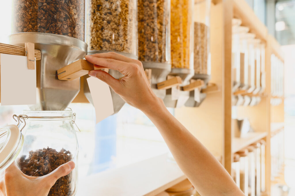 Cliente utiliza dispensador de alimentos em franquia de produtos a granel